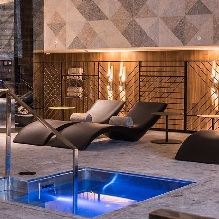 Grand Hyatt Barcelona Ξενοδοχείο Εξωτερικό φωτογραφία The photo shows a modern spa or relaxation area. In the foreground, there is a small rectangular pool of water with a sleek metal railing. Surrounding the pool are comfortable lounge chairs, designed for relaxation, likely positioned for users to unw